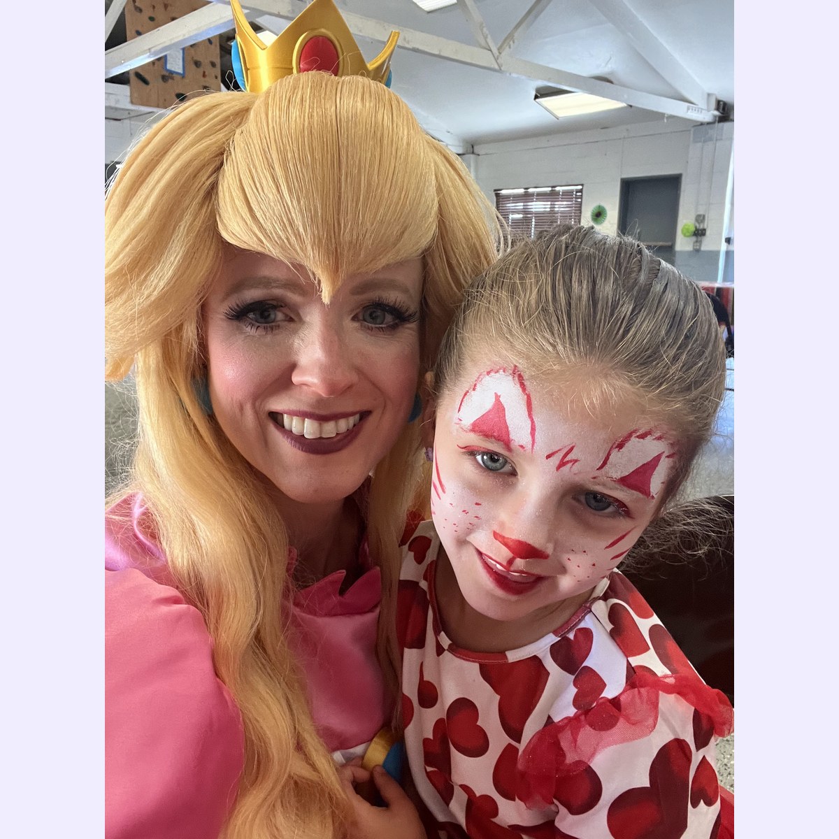 Character performer with a child showing party face paint